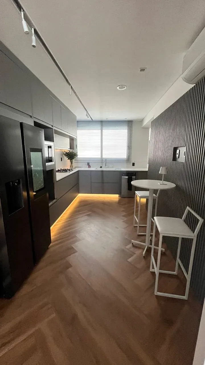Cozinha integrada com ripado e iluminação