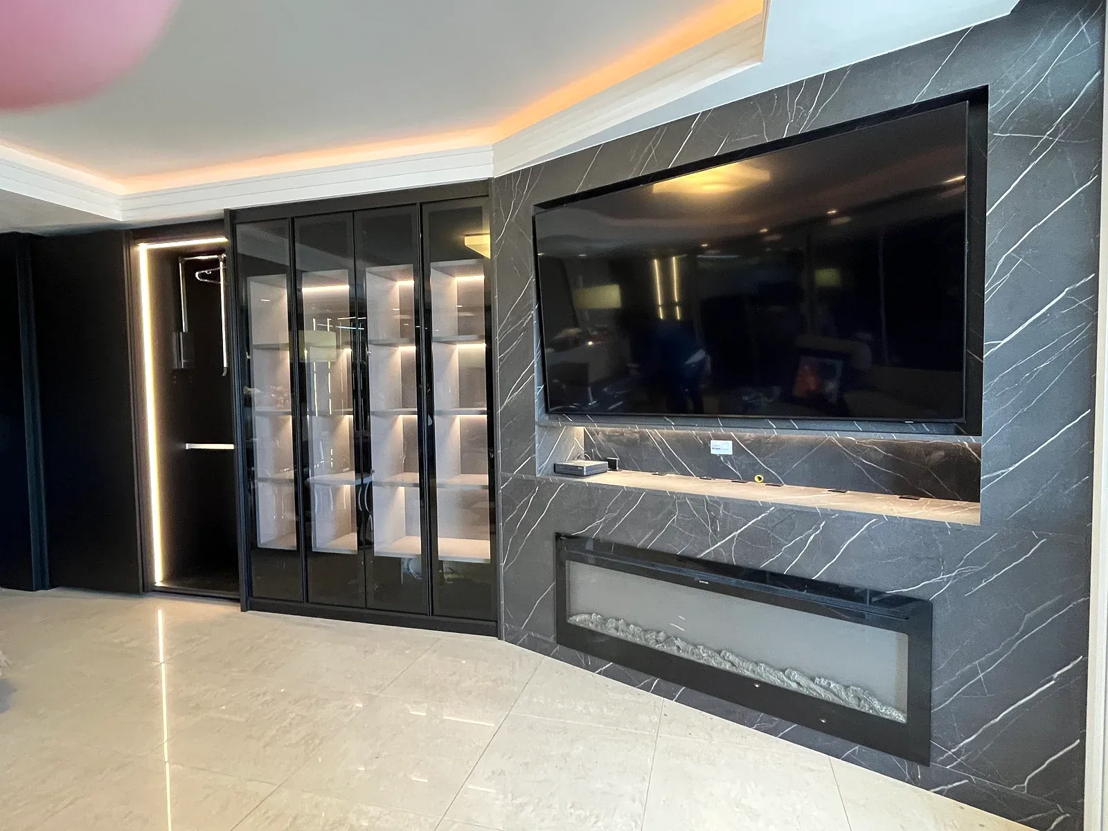 Sala planejada com painel de TV e cristaleira iluminada